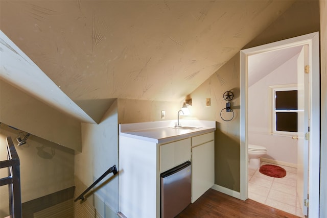 520 N College St, Waxahachie, TX 75165 - bathroom featuring lofted ceiling, toilet, baseboards, vanity, and wood finished floors