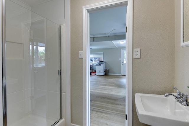 520 N College St, Waxahachie, TX 75165 - bathroom with a sink, a shower stall, wood finished floors, and a textured wall