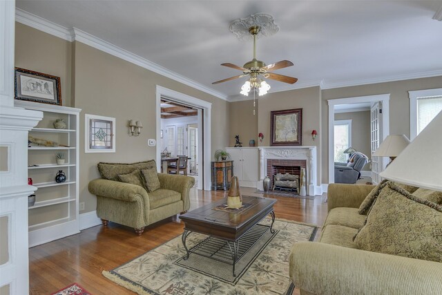 520 N College St, Waxahachie, TX 75165 - living area featuring wood finished floors, ornamental molding, a ceiling fan, a fireplace, and baseboards