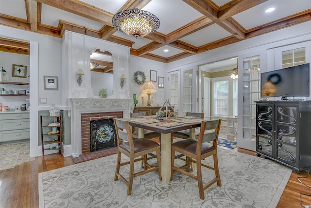 520 N College St, Waxahachie, TX 75165 - dining area with beamed ceiling, coffered ceiling, wood finished floors, a brick fireplace, and ornamental molding