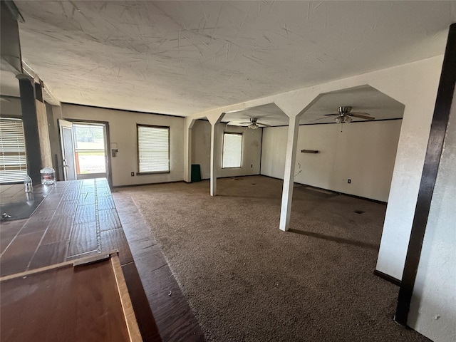 309 E Housley St, Strawn, TX 76475 - unfurnished living room featuring ceiling fan, arched walkways, and baseboards