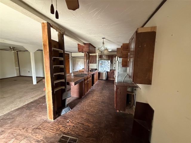 309 E Housley St, Strawn, TX 76475 - kitchen featuring a ceiling fan, dark countertops, hanging light fixtures, and dark brown cabinetry