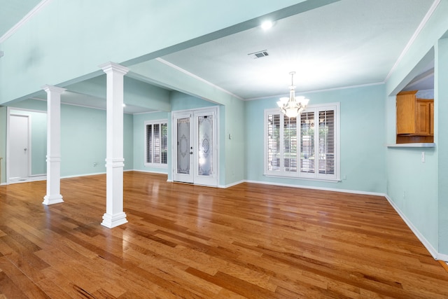 2621 Brennan Ct, Plano, TX 75075 - unfurnished living room featuring ornate columns, light wood-style floors, baseboards, a chandelier, and ornamental molding