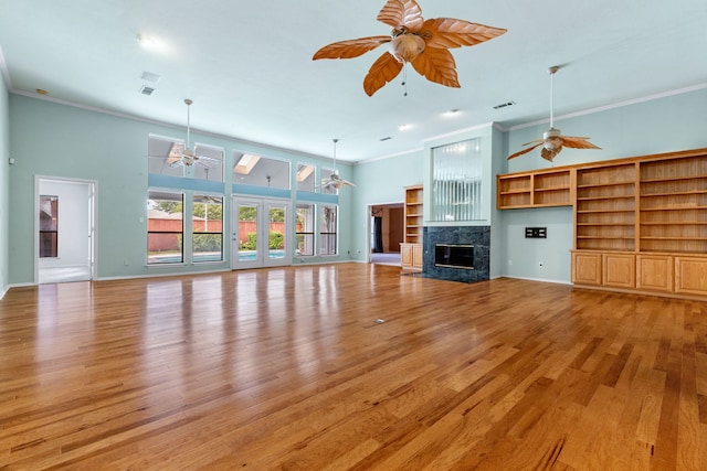 2621 Brennan Ct, Plano, TX 75075 - unfurnished living room with ceiling fan, crown molding, light wood finished floors, a fireplace, and a high ceiling