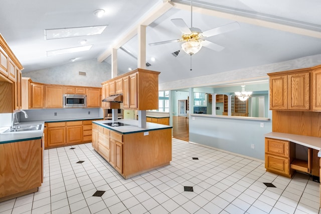 2621 Brennan Ct, Plano, TX 75075 - kitchen with a sink, stainless steel microwave, under cabinet range hood, a skylight, and light tile patterned flooring