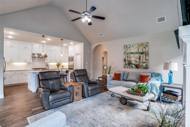 9712 Surveyor Rd, Little Elm, TX 75068 - living area featuring arched walkways, ceiling fan, dark wood-style floors, and high vaulted ceiling