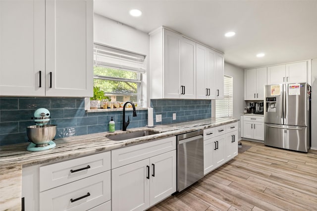 7251 Valley Dale Ct, Benbrook, TX 76116 - kitchen with stainless steel appliances, white cabinets, light wood-type flooring, light stone countertops, and backsplash