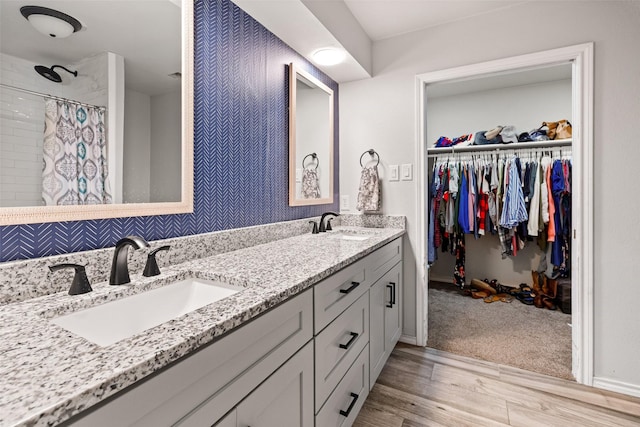 7251 Valley Dale Ct, Benbrook, TX 76116 - full bathroom featuring wood finished floors, double vanity, a walk in closet, and tiled shower