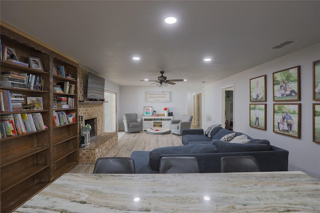 7251 Valley Dale Ct, Benbrook, TX 76116 - living room with light wood finished floors, a ceiling fan, a fireplace, and recessed lighting