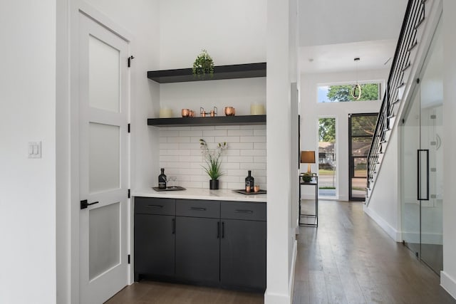 4233 Skillman St, Dallas, TX 75206 - indoor dry bar featuring dark wood-style flooring, stairway, tasteful backsplash, and baseboards
