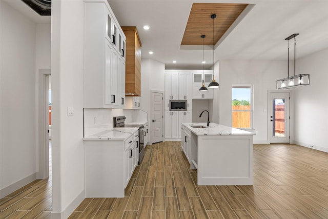 5845 Black Pine Cir, Granbury, TX 76048 - kitchen featuring appliances with stainless steel finishes, a sink, light wood-style floors, baseboards, and light stone counters