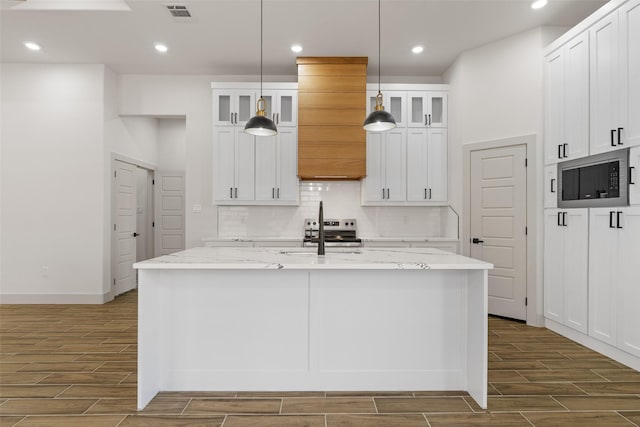 5845 Black Pine Cir, Granbury, TX 76048 - kitchen with a sink, wood finish floors, appliances with stainless steel finishes, backsplash, and white cabinetry