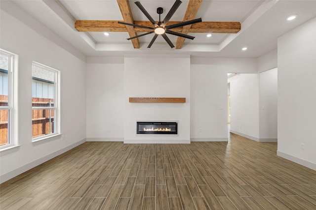 5845 Black Pine Cir, Granbury, TX 76048 - unfurnished living room with coffered ceiling, wood finished floors, a glass covered fireplace, beamed ceiling, and baseboards
