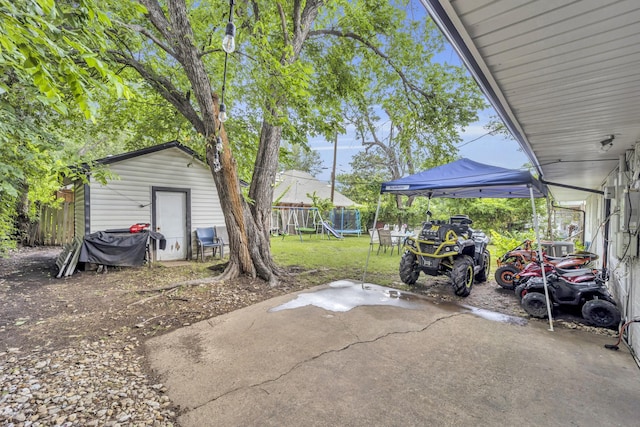 2605 Himes St, Irving, TX 75060 - view of patio / terrace featuring a trampoline and an outbuilding