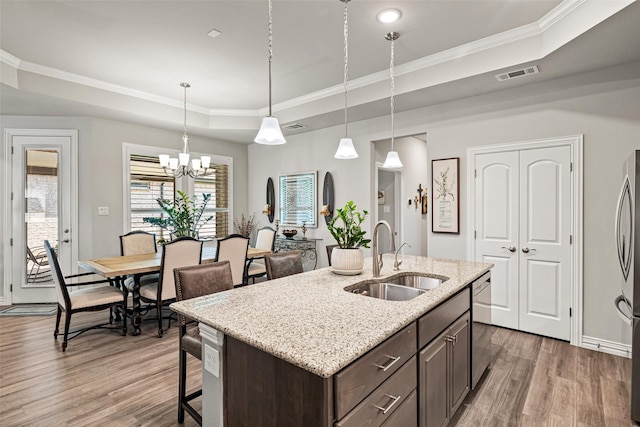 7700 Cerrito Trl, Fort Worth, TX 76123 - kitchen featuring a sink, a raised ceiling, wood finished floors, appliances with stainless steel finishes, and dark brown cabinetry