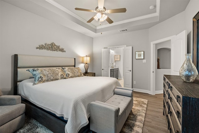 7700 Cerrito Trl, Fort Worth, TX 76123 - bedroom with a tray ceiling, wood finished floors, baseboards, connected bathroom, and ornamental molding
