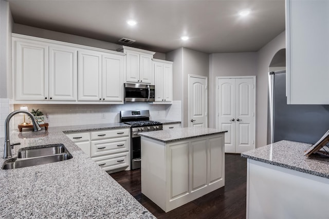 2637 Hillrich Dr, Anna, TX 75409 - kitchen with stainless steel appliances, a sink, white cabinets, decorative backsplash, and light stone countertops