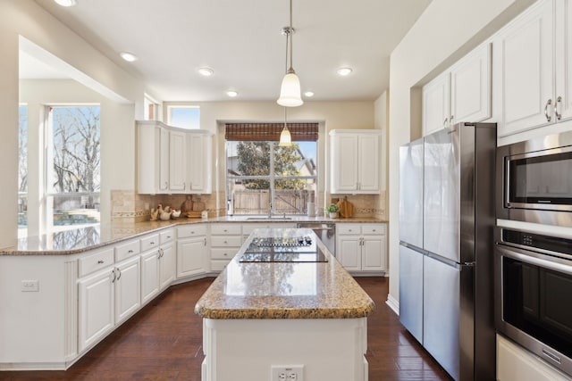 1415 Cambridge Xing, Southlake, TX 76092 - kitchen featuring appliances with stainless steel finishes, a center island, white cabinetry, light stone countertops, and recessed lighting