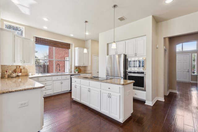 1415 Cambridge Xing, Southlake, TX 76092 - kitchen with appliances with stainless steel finishes, decorative backsplash, a kitchen island, light stone counters, and recessed lighting