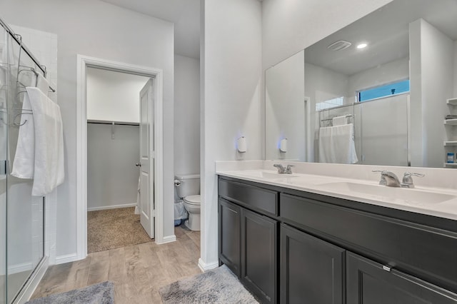 9752 New Bern Dr, Fort Worth, TX 76108 - full bath featuring wood finished floors, a shower stall, double vanity, toilet, and a spacious closet
