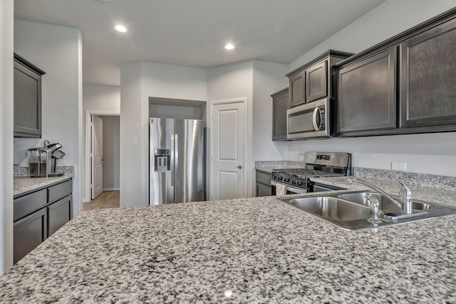9752 New Bern Dr, Fort Worth, TX 76108 - kitchen featuring stainless steel appliances, a sink, dark brown cabinetry, recessed lighting, and light stone counters