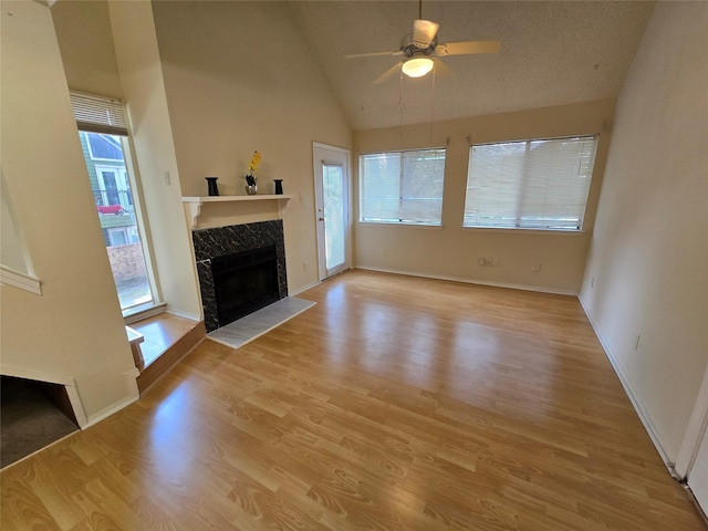 9835 Walnut St Unit 203, Dallas, TX 75243 - unfurnished living room with a tile fireplace, a ceiling fan, light wood-type flooring, baseboards, and high vaulted ceiling