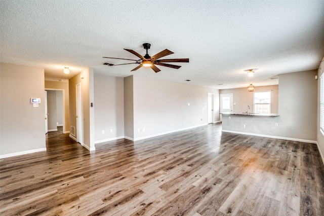 319 Quail Crossing Dr, Sanger, TX 76266 - unfurnished living room featuring wood finished floors, a textured ceiling, a ceiling fan, and baseboards