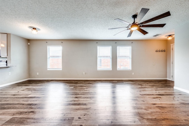 319 Quail Crossing Dr, Sanger, TX 76266 - empty room with a textured ceiling, ceiling fan, wood finished floors, and baseboards