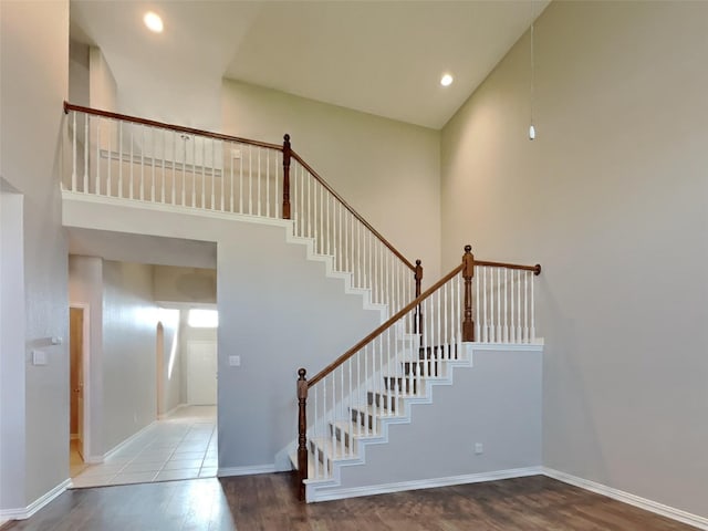 1104 Cactus Spine Dr, Fort Worth, TX 76052 - stairs featuring wood finished floors, a towering ceiling, baseboards, and recessed lighting