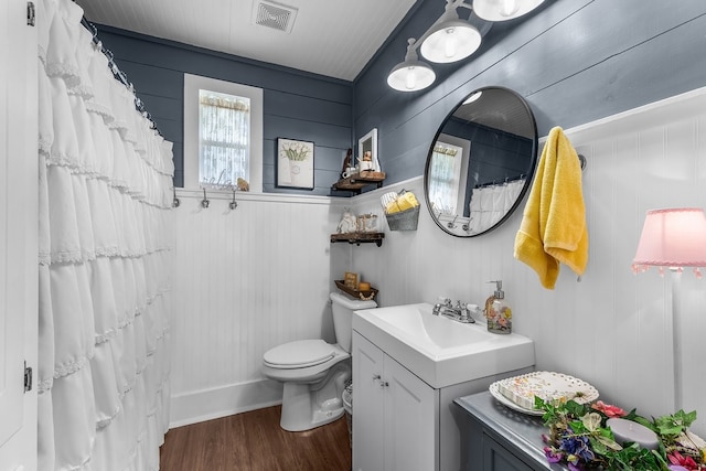 6440 Harmonson Rd, North Richland Hills, TX 76180 - full bathroom featuring vanity, toilet, wood finished floors, and curtained shower