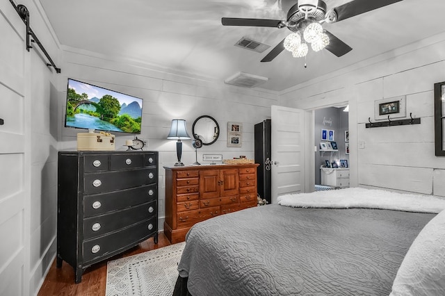 6440 Harmonson Rd, North Richland Hills, TX 76180 - bedroom featuring wood finished floors, a barn door, and ceiling fan