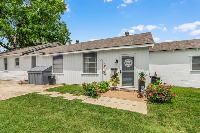 6440 Harmonson Rd, North Richland Hills, TX 76180 - view of front facade featuring a front lawn, a shingled roof, board and batten siding, and a patio
