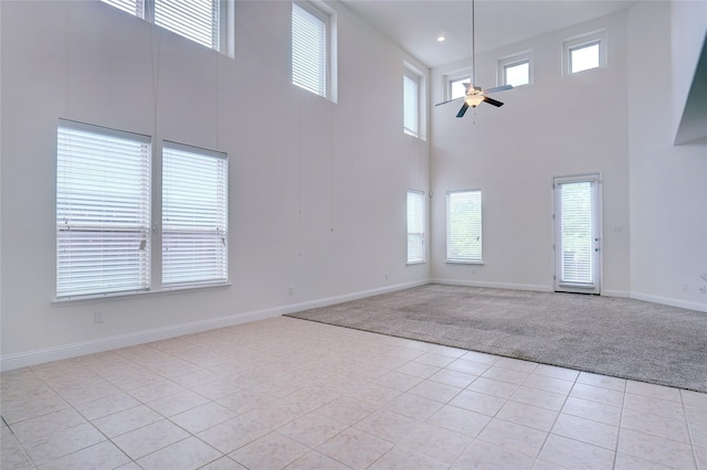 8721 Maple Ridge Rd, Fort Worth, TX 76244 - empty room with light colored carpet, light tile patterned flooring, a towering ceiling, a ceiling fan, and baseboards