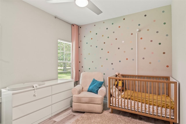103 Idlewood Rd, Enchanted Oaks, TX 75156 - bedroom with wood finished floors, a crib, a ceiling fan, and wallpapered walls