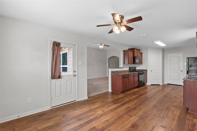 2118 Cone Flower Dr, Forney, TX 75126 - kitchen with black appliances, a ceiling fan, arched walkways, dark wood-type flooring, and brown cabinets