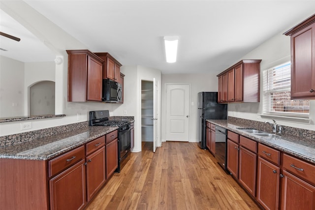 2118 Cone Flower Dr, Forney, TX 75126 - kitchen featuring black appliances, a sink, light wood-type flooring, dark stone counters, and a ceiling fan