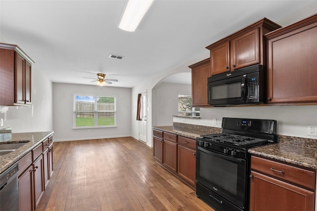 2118 Cone Flower Dr, Forney, TX 75126 - kitchen with black appliances, healthy amount of natural light, arched walkways, and light wood-style flooring