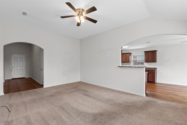 2118 Cone Flower Dr, Forney, TX 75126 - unfurnished living room with carpet flooring, a ceiling fan, arched walkways, baseboards, and vaulted ceiling