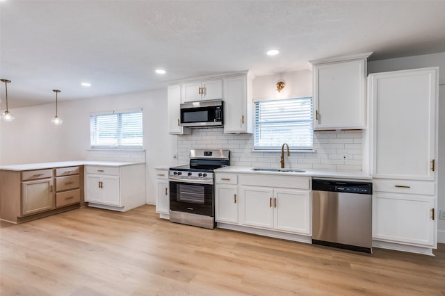 611 Cannon Dr, Euless, TX 76040 - kitchen featuring stainless steel appliances, a sink, tasteful backsplash, light wood-style flooring, and light countertops