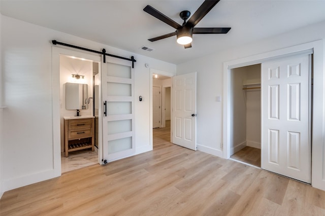 611 Cannon Dr, Euless, TX 76040 - unfurnished bedroom with light wood-style floors, a barn door, a closet, and baseboards