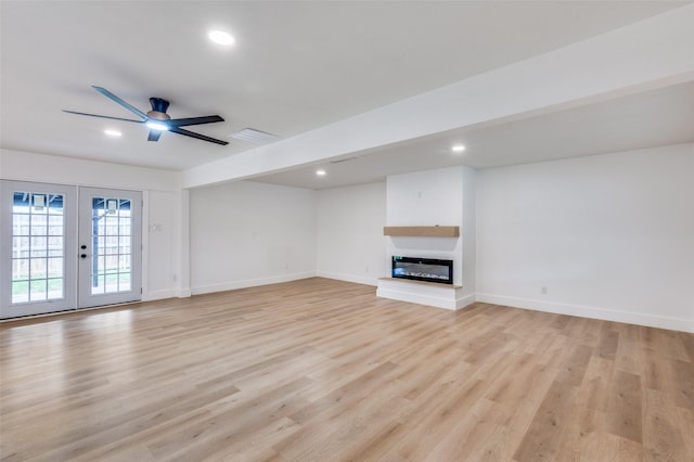 611 Cannon Dr, Euless, TX 76040 - unfurnished living room with light wood finished floors, a ceiling fan, french doors, a glass covered fireplace, and recessed lighting