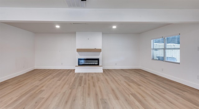 611 Cannon Dr, Euless, TX 76040 - unfurnished living room with light wood finished floors, a glass covered fireplace, baseboards, and recessed lighting