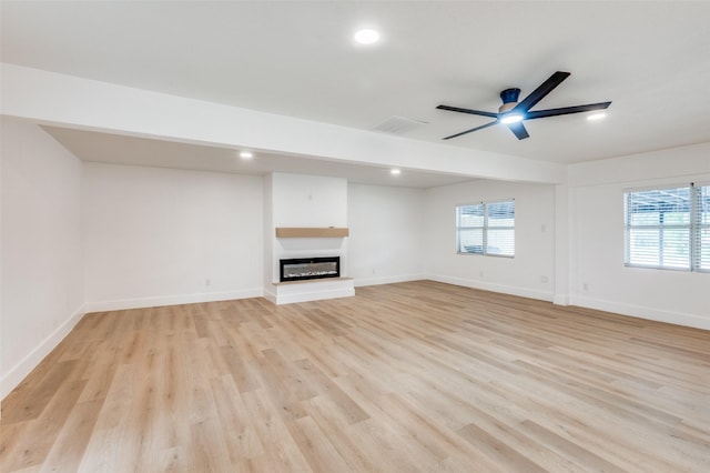 611 Cannon Dr, Euless, TX 76040 - unfurnished living room featuring a glass covered fireplace, a ceiling fan, light wood-style floors, healthy amount of natural light, and recessed lighting