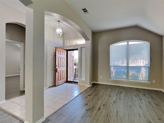 529 Covey Trl, Rockwall, TX 75087 - foyer with arched walkways, lofted ceiling, wood finished floors, and baseboards
