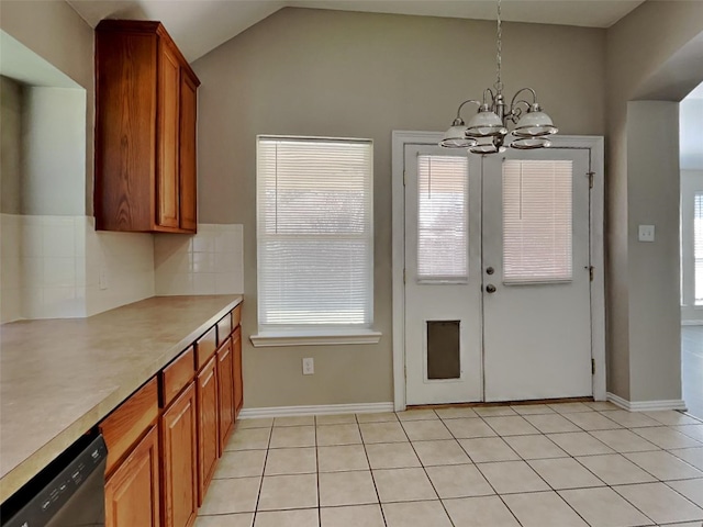 529 Covey Trl, Rockwall, TX 75087 - kitchen with a chandelier, brown cabinetry, stainless steel dishwasher, light countertops, and lofted ceiling