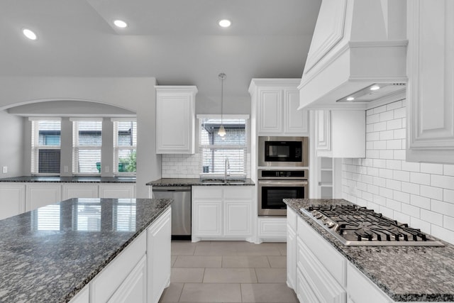 2111 Devonblue Dr, Forney, TX 75126 - kitchen with stainless steel appliances, custom range hood, a sink, tasteful backsplash, and white cabinetry