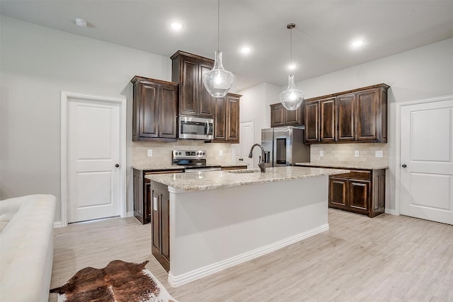 812 Porcupine Dr, Springtown, TX 76082 - kitchen featuring appliances with stainless steel finishes, light wood-type flooring, backsplash, dark brown cabinetry, and recessed lighting