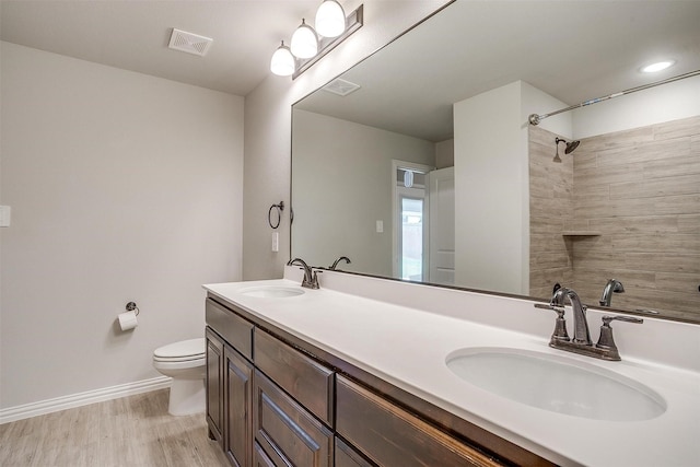 812 Porcupine Dr, Springtown, TX 76082 - bathroom with toilet, baseboards, double vanity, wood finished floors, and a shower