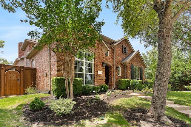 9 Haywood Ct, Frisco, TX 75035 - view of front facade with brick siding, a gate, and a chimney