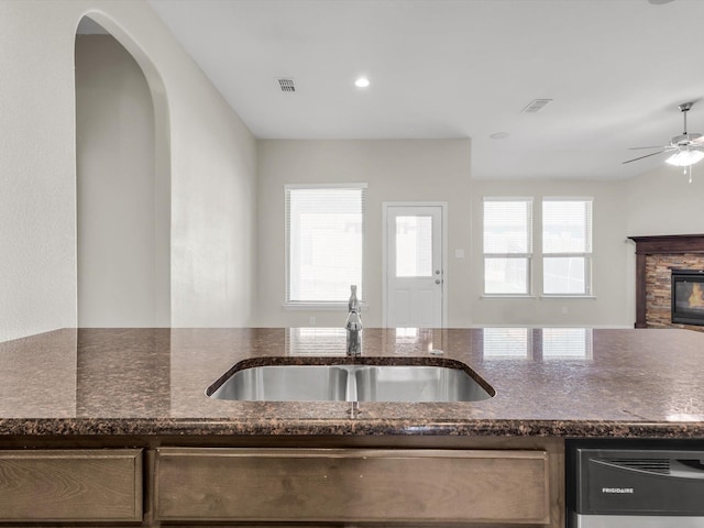 14824 Angel Trace Dr, Aledo, TX 76008 - kitchen featuring a sink, dark stone counters, dishwashing machine, ceiling fan, and open floor plan